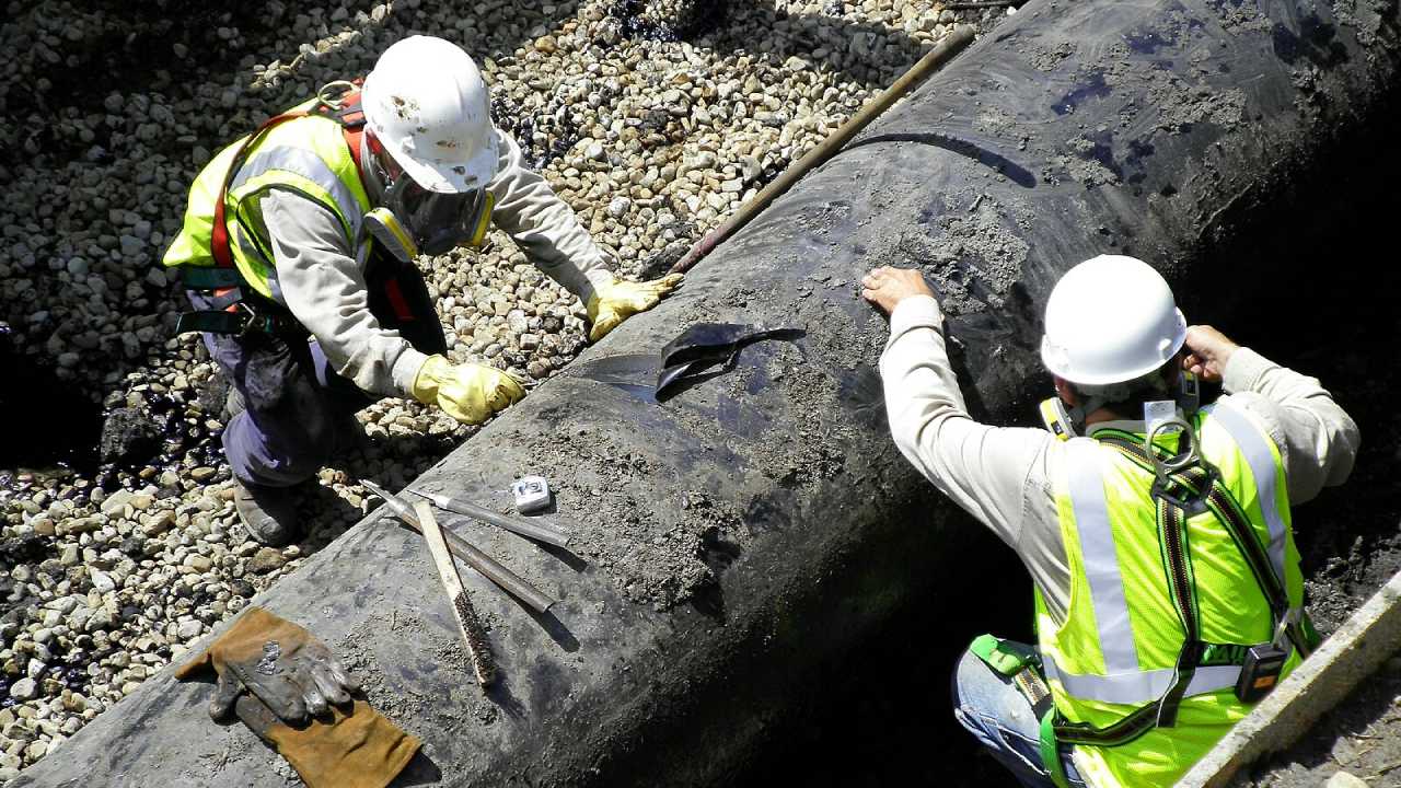 workers preparing pipeline for welding