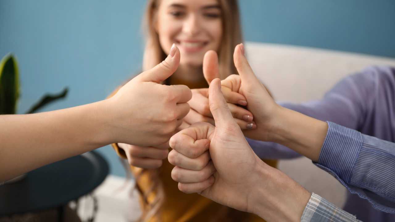 group of people putting thumbs up